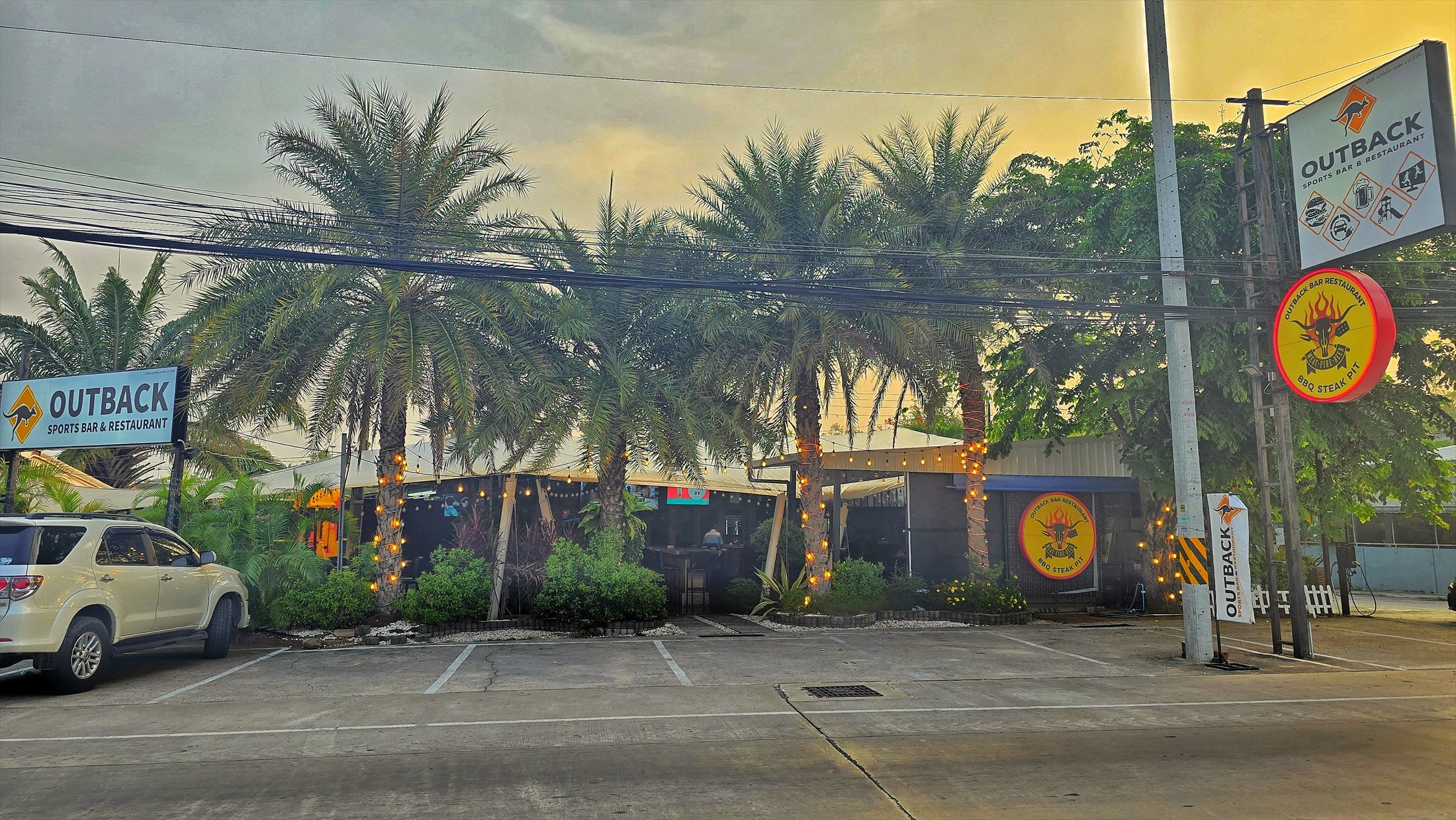 Outback exterior with palm trees at dusk